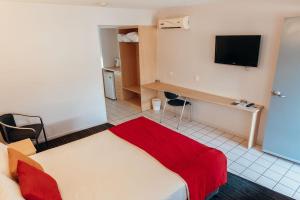 ein Hotelzimmer mit einem Bett und einem Flachbild-TV in der Unterkunft The Mayfair Ridge Hotel in Emerald