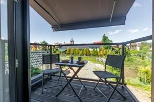 a patio with a table and chairs on a balcony at FLORENCJA - nowy apartament w centrum miasta z KLIMATYZACJĄ oraz zadaszonym parkingiem w cenie in Nowy Targ