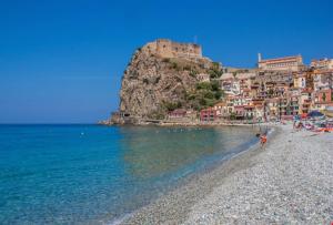 a group of people on a beach near the water at Stella Marina in Scilla