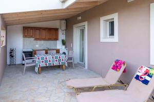 a patio with chairs and a table and a kitchen at Christiana's Cottage in Sidari