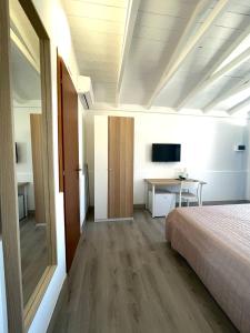 a bedroom with a bed and a desk and a television at Aldiva Chalet in Torvaianica +20 photos