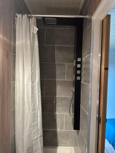 HazelbourgにあるHOME SÉRÉNITÉのシャワーカーテン付きのシャワー付きバスルーム