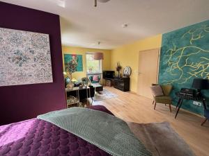 a bedroom with a purple bed and a living room at Atelier Farbenreich No 8 in Eching