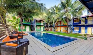 莫尔吉姆Treebo Sava Resort with Pool的棕榈树度假村前的游泳池