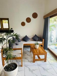 sala de estar con sofá y algunas plantas en Santai Retreat, en Kuta Lombok