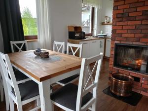 a kitchen with a wooden table and a fireplace at Brzozowy Zagajnik Bieszczady - Domki z Balia Ogrodowa in Bereżnica Wyżna