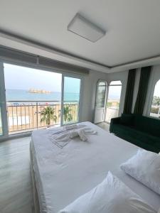 a bedroom with a bed with a view of the ocean at Hotel Angel Beach - Kızkalesi Mersin in Erdemli
