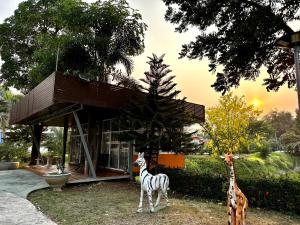 two fake giraffes standing in front of a house at MJ RESORT in Nong Phai