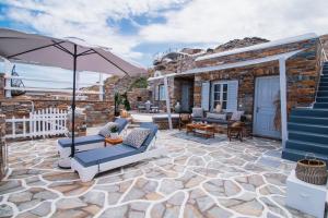 a patio with two couches and an umbrella at KL , Cozy Suite II in Kithnos