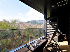 a balcony with a bench and a view of the mountains at Hotel Morinokaze Hakone Sengokuhara in Hakone