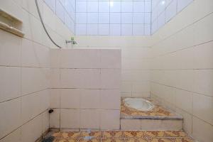 a tiled room with a urinal in a room at Wisma 812 Khusus Putra for Male Only in Bandung +8 photos