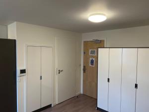 an empty room with two white cabinets and a door at Cosy Private Ensuites and Studios in the heart of Cheltenham in Cheltenham