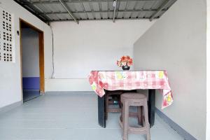 a table with two stools with a table cloth on it at Wisma 812 Khusus Putra for Male Only in Bandung