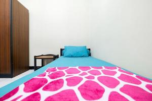 a bedroom with a bed with a pink and white blanket at Wisma 812 Khusus Putra for Male Only in Bandung