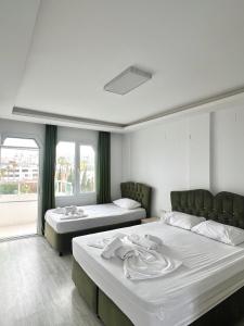 a room with two beds and two windows at Angel Beach Hotel Kızkalesi Mersin in Erdemli