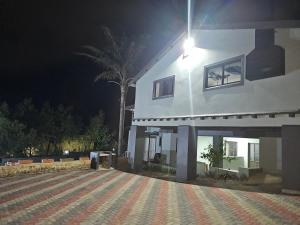 a house at night with a palm tree in front at The Haven: Make our Home your Home in Estcourt