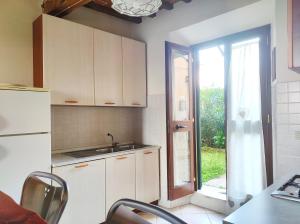a kitchen with a sink and a refrigerator and a window at La Casina di Colle in Casciana Terme