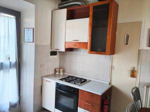 a kitchen with white cabinets and a stove top oven at La Casina di Colle in Casciana Terme