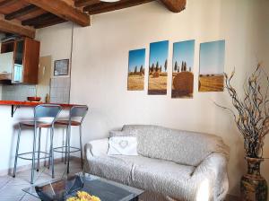a living room with a couch and some pictures on the wall at La Casina di Colle in Casciana Terme