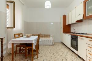 een keuken met een tafel en stoelen en een keuken met een bank bij Villa Septis in Ostuni in Ostuni