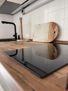 a counter in a kitchen with a wooden cutting board at Ferienwohnung Strandoase inklusive Terrasse und Parkplatz - Sonnenseite in Scharbeutz