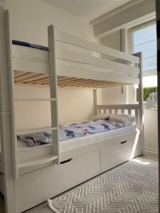 a bedroom with two bunk beds and a window at Ferienwohnung Strandoase inklusive Terrasse und Parkplatz - Sonnenseite in Scharbeutz