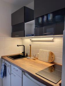a kitchen with a sink and a counter top at Ferienwohnung Strandoase inklusive Terrasse und Parkplatz - Sonnenseite in Scharbeutz