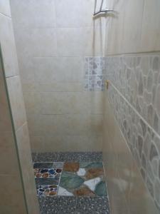 ein Bad mit einer Dusche und Fliesenboden in der Unterkunft Hill View Home Stay in Panglao