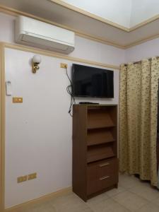 a room with a flat screen tv on a wall at Hill View Home Stay Bohol in Panglao