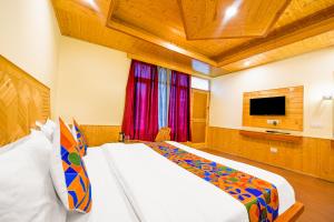 a bedroom with a large bed and a television at FabHotel Brave Knight in Manāli
