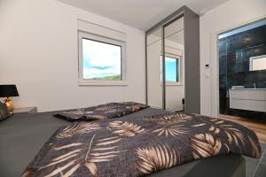 una camera da letto con due letti e una grande finestra di Penthouse Bluesky a Okrug Gornji Altre 54 foto