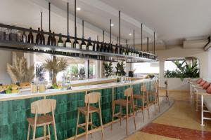 阿德赫的住宿－AluaSoul Costa Adeje，一间铺有绿色瓷砖并配有木凳的酒吧