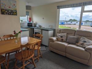 a living room with a couch and a table at Hemsby Holiday Home - Norfolk beach & seaside fun in Great Yarmouth