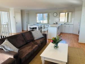 sala de estar con sofá marrón y cocina en Nellies Hideaway 1-20 Troon Drive, en Normanville 22 fotos más