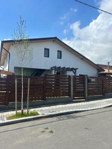 a house with a wooden fence in front of it at Casa.Puf in Techirghiol