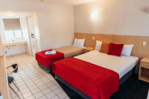 ein Hotelzimmer mit 2 Betten und einem Tisch in der Unterkunft The Mayfair Ridge Hotel in Emerald