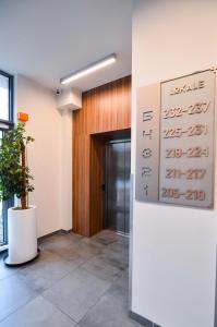 un hall de bureau avec un panneau sur un mur dans l'établissement CITYSTAY Garden Gates Apartment, à Gdańsk