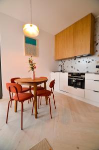 kuchnia z drewnianym stołem i krzesłami w obiekcie CITYSTAY Garden Gates Apartment w Gdańsku