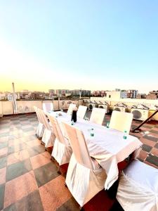 a row of tables and white chairs on a roof at JB Residency !! Top Rated & Most Awarded Property in Tricity !! in Chandīgarh
