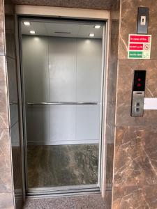 una puerta del ascensor de cristal en un edificio en JB Residency !! Top Rated & Most Awarded Property in Tricity !!, en Chandīgarh