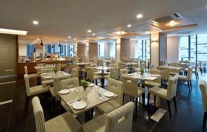 a restaurant with tables and chairs in a room at Hotel Transit Kuala Lumpur in Kuala Lumpur