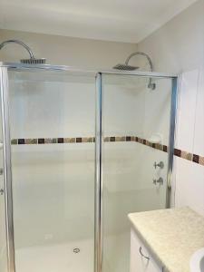 una ducha de cristal en un baño con encimera en Nellies Hideaway 1-20 Troon Drive, en Normanville