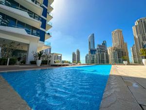 een zwembad met een skyline van de stad op de achtergrond bij Marco Polo - Stunning 2 BR With Marina Views, Huge Pool & Gym in Dubai