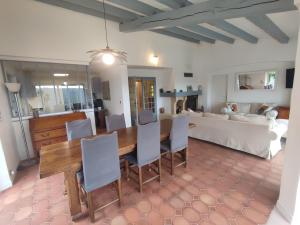 uma sala de jantar e sala de estar com mesa e cadeiras em Les Reflets du Lac em Esparron-de-Verdon
