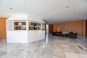 een lobby met een witte muur en een woonkamer bij Kiko Las Americas in Isla Cristina