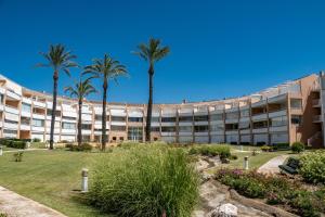 an exterior view of a building with palm trees at Kiko Las Americas in Isla Cristina