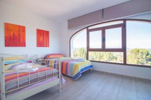 a bedroom with two beds and a large window at Villa Rosario - PlusHolidays in Calpe +37 photos