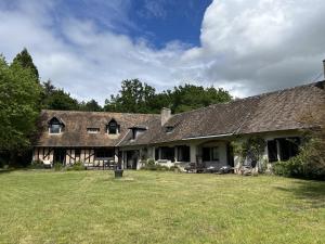 una vecchia casa con un prato davanti di La Clairière - Le Calme de la Campagne - 9 pers a Parigné-lʼÉvêque
