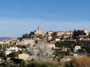 ein Dorf auf einem Hügel mit einer Kirche in der Unterkunft LE CHARME DU VENTOUX in Crillon-le-Brave