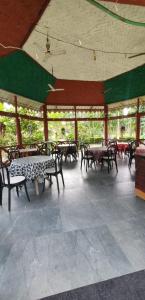 einem Pavillon mit Tischen und Bänken in einem Gebäude in der Unterkunft Ayush Jungle Resort in Jalpāiguri